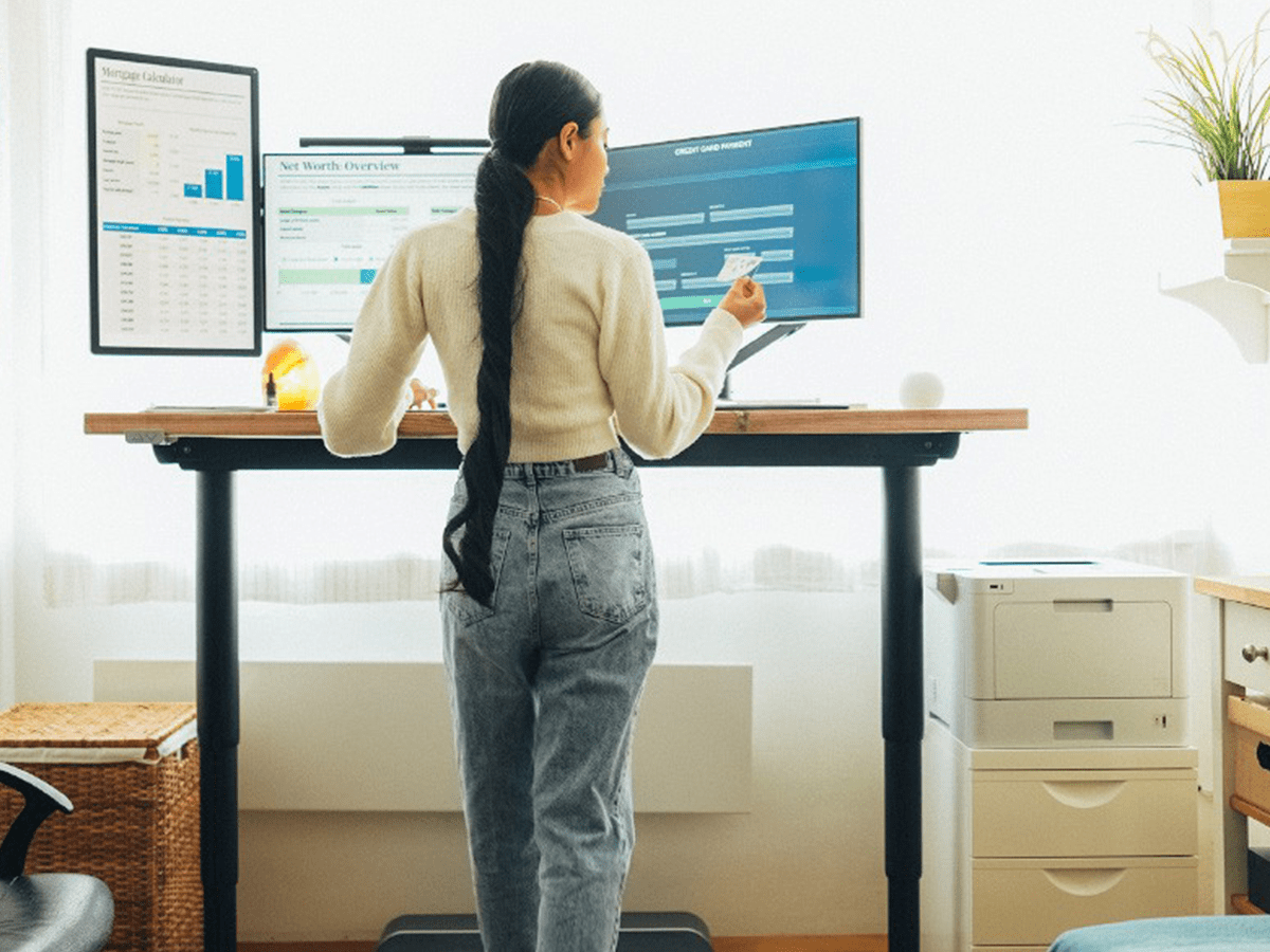Woman standing at desk reviewing 2024 employee well-being trends
