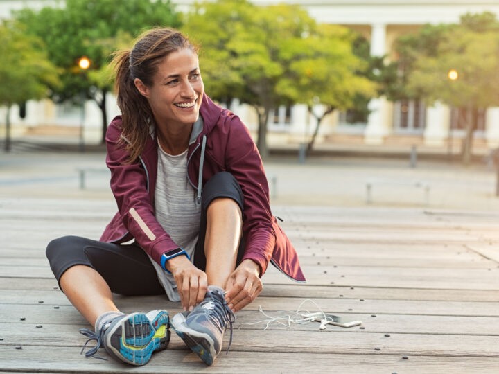 Woman tying her shoes before she goes on a run